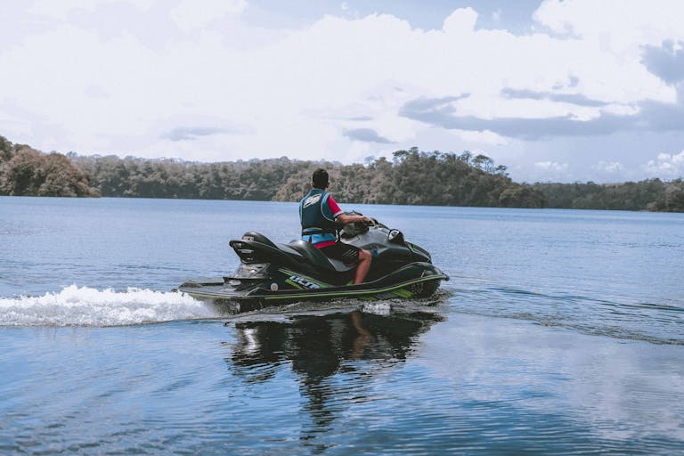 Man Riding Jetski on Body of Water