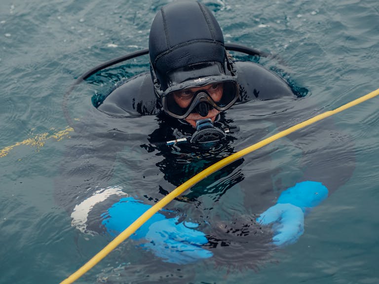 Scuba Diver on Water Surface Holding a Sea Urchin